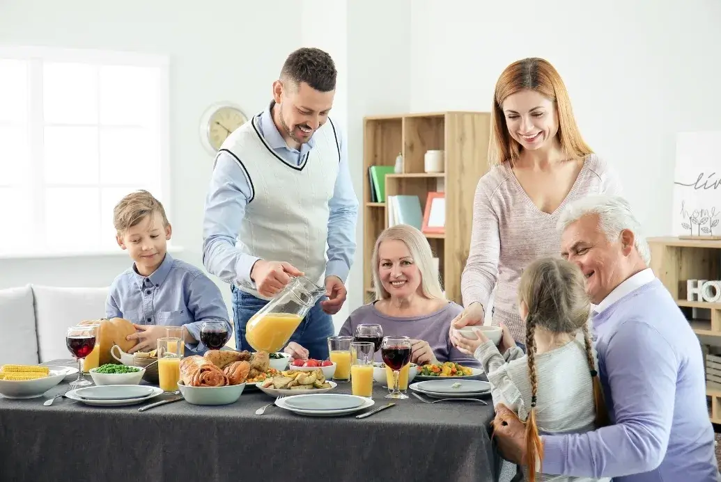 Family gathered around a festive Thanksgiving table, smiling and sharing a joyful meal